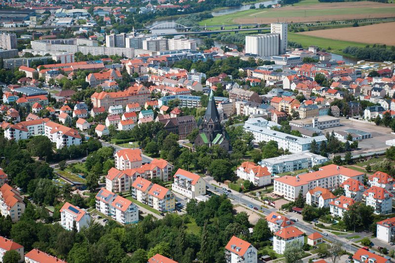 Luftaufnahme von Riesa mit Wohnbebauung, Kirche und Industrieanlagen am Stadtrand