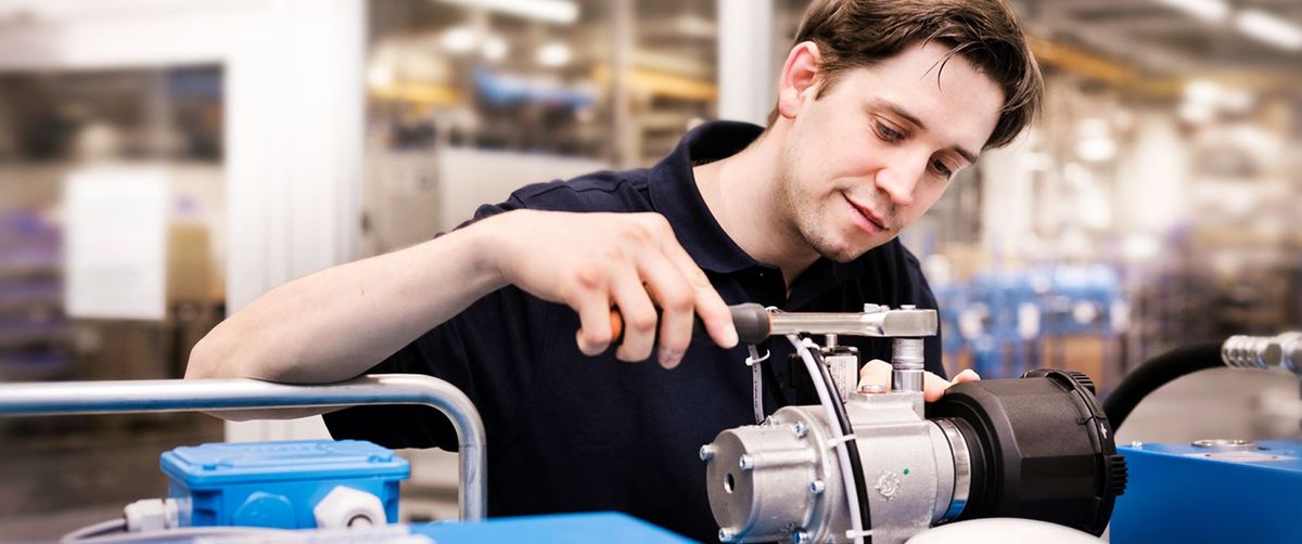 Techniker von BOGE Komponenten montiert ein Bauteil an einem Werkstattwagen