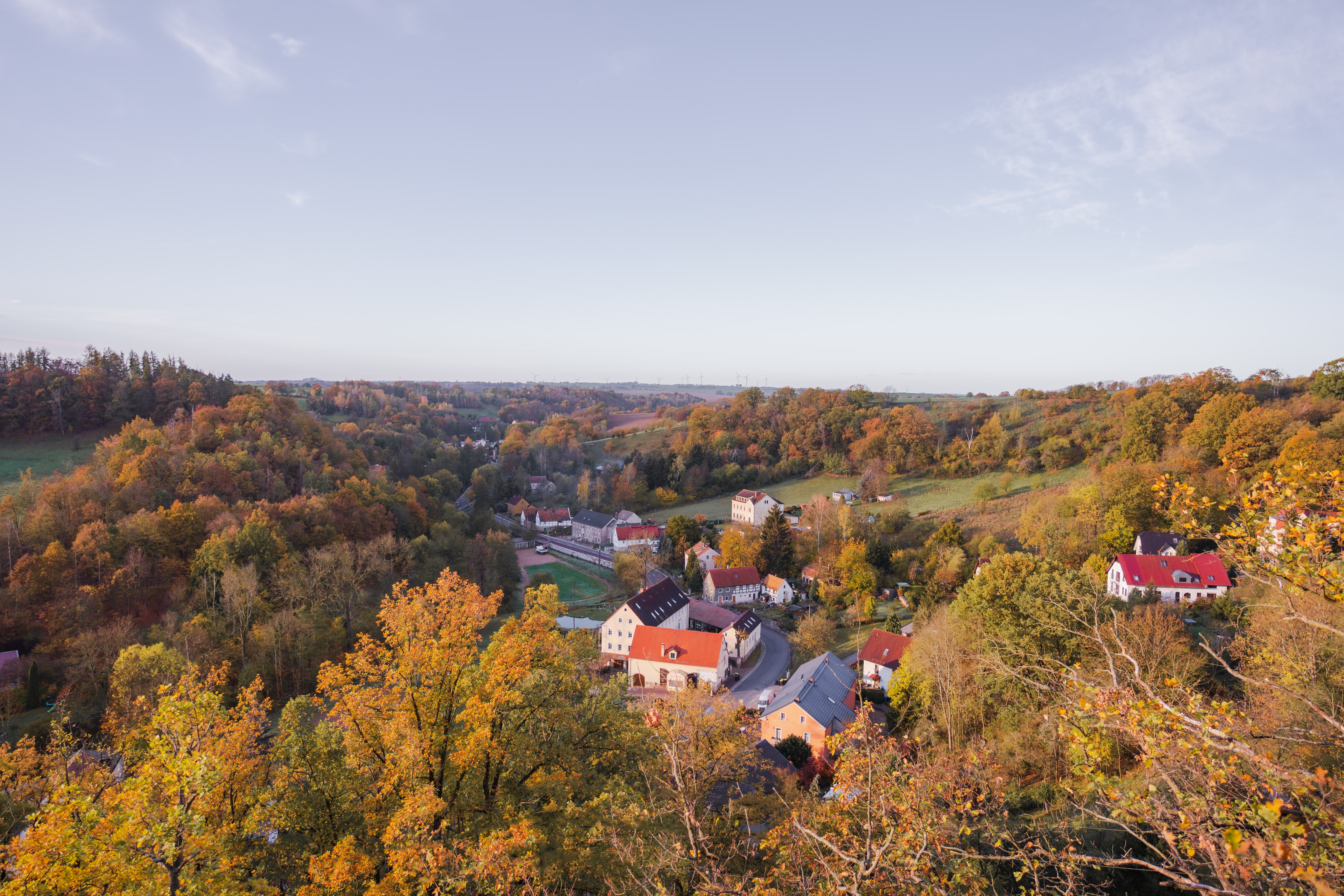 Herbstlicher Blick über die bewaldeten Hänge auf den Ort Klipphausen