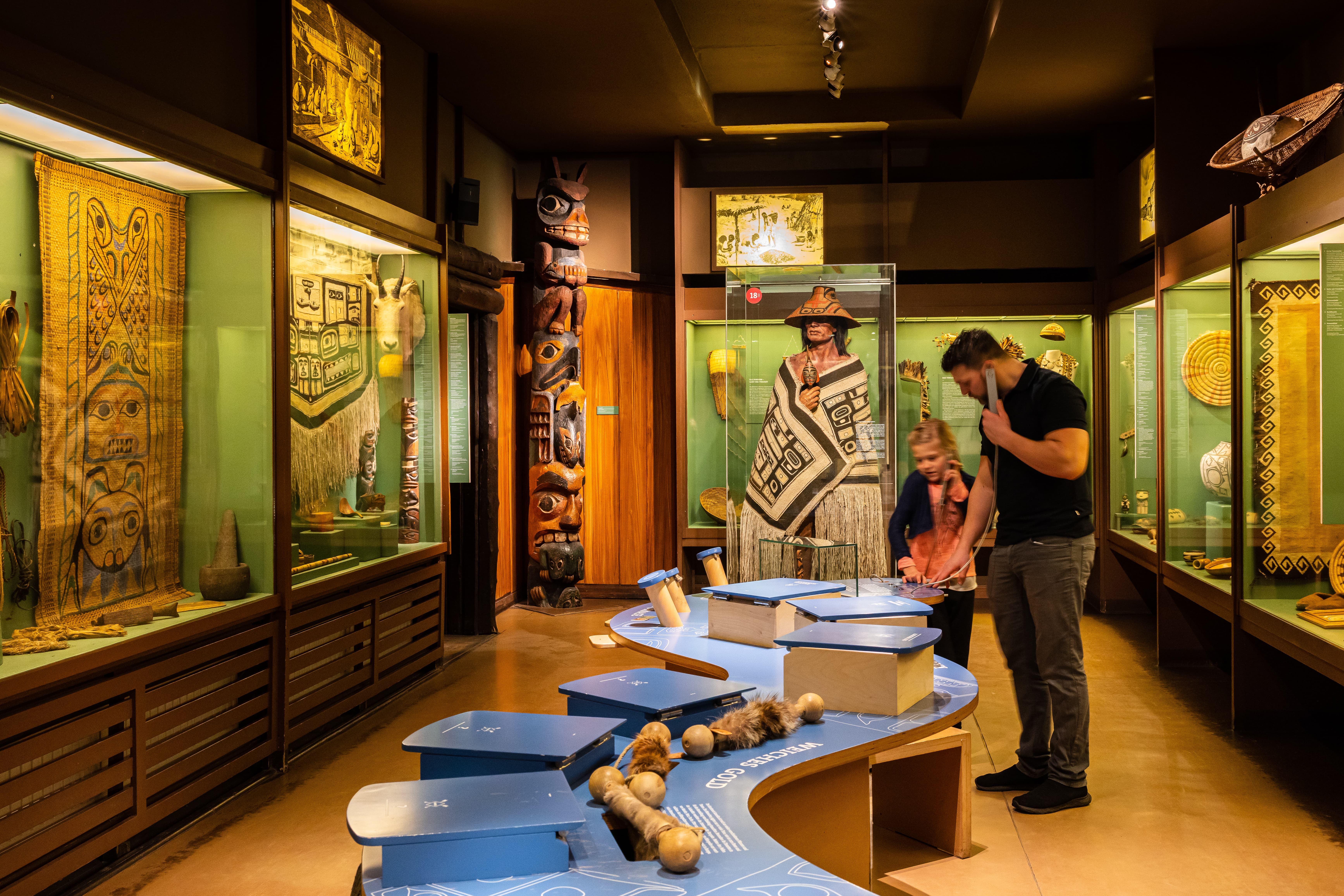 Besucher betrachten Ausstellungsvitrinen mit indianischen Exponaten im Karl-May-Museum Radebeul