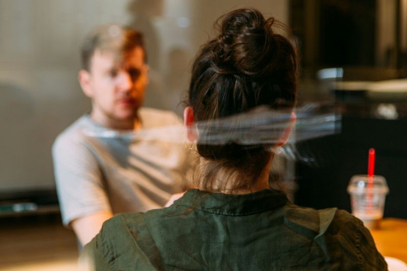 Zwei Personen sitzen sich bei einem Gespräch an einem Tisch gegenüber