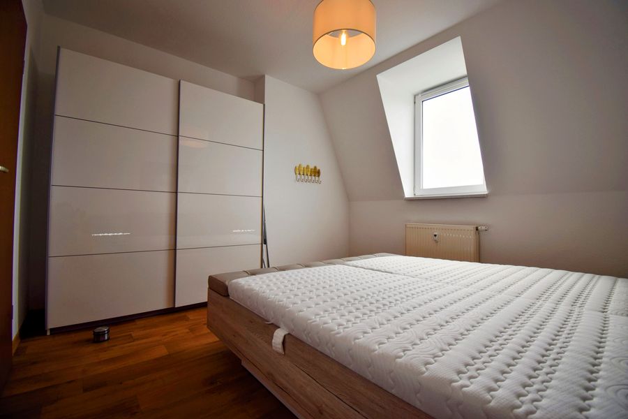 Möbliertes Schlafzimmer mit Doppelbett und Einbauschrank in einer Wohnung der Wohnungsgesellschaft Riesa
