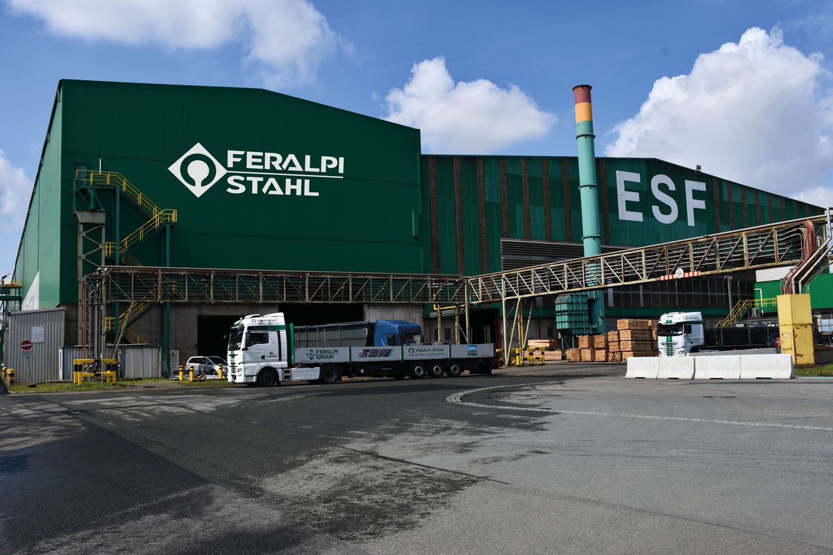 Grüne Werkshalle von Feralpi Stahl in Riesa mit Lkw auf dem Werksgelände